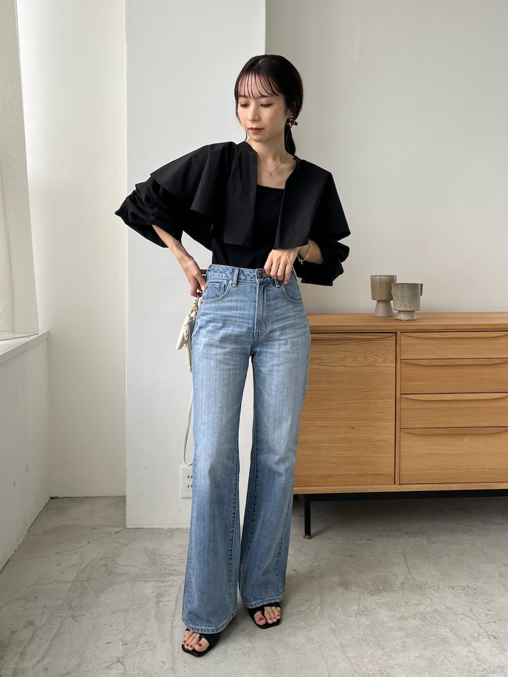 ブラック系のシャツ/ブラウス、ブルー系のデニムパンツ、ホワイト系のトートバッグを着用したレディースの夏コーディネートの2枚目の写真