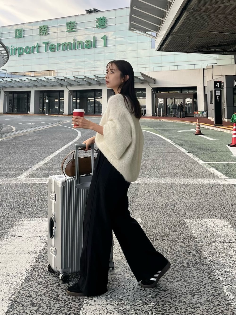 ブラック系のスウェットパンツ、ホワイト系のニット/セーター、ブラック系のスニーカーを着用したレディースの秋コーディネートの6枚目の写真