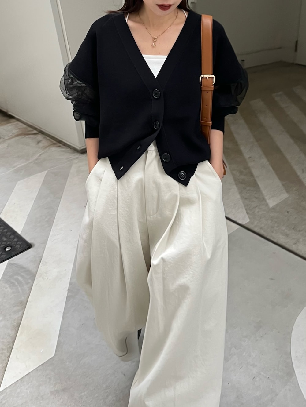 ホワイト系のその他パンツ、ブラック系のカーディガン/ボレロ、ベージュ系のショルダーバッグを着用したレディースの春コーディネートの3枚目の写真