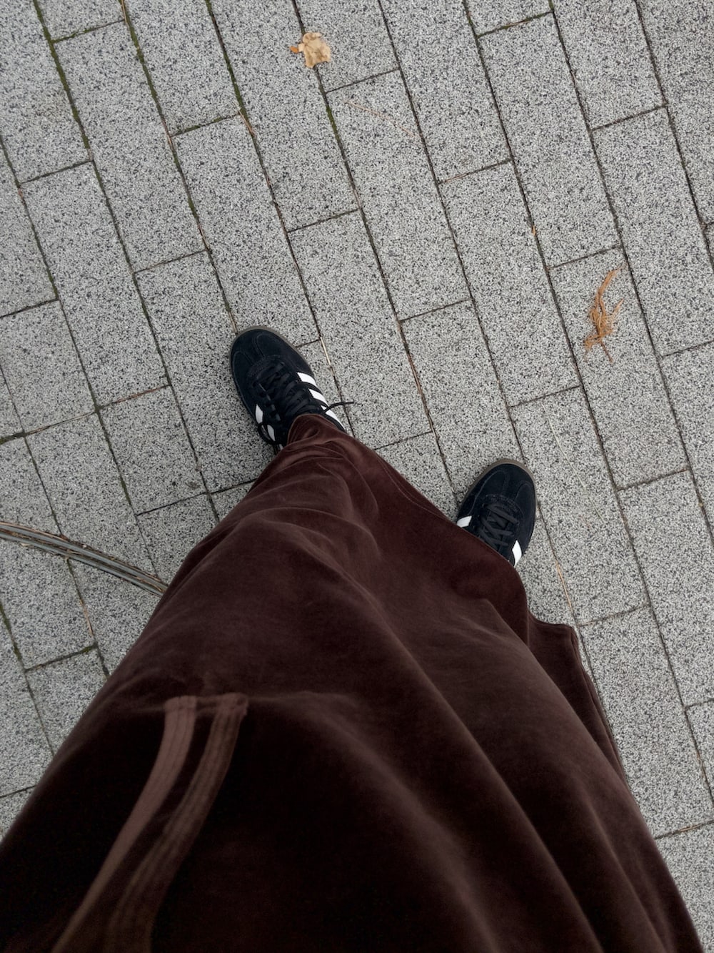 ホワイト系のバッグ、ブラウン系のワンピース、ブラック系のスニーカーを着用したレディースの冬コーディネートの5枚目の写真