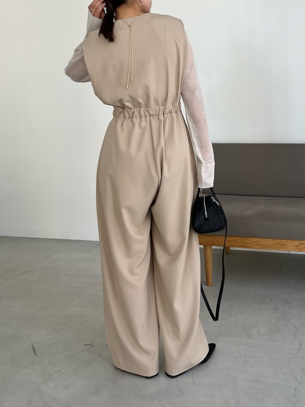 ブラック系のパンプス、ホワイト系のニット/セーター、ベージュ系のつなぎ/オールインワンを着用したレディースの冬コーディネートの3枚目の写真