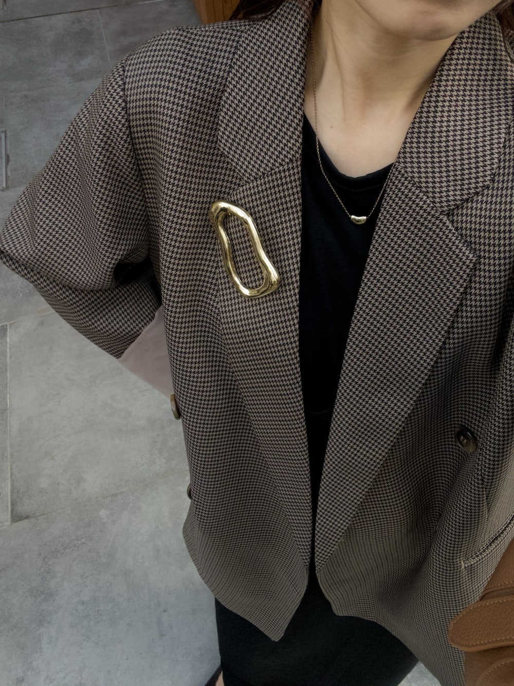 ブラック系のワンピース、ブラウン系のテーラードジャケット、ブラウン系のショルダーバッグを着用したレディースの秋コーディネートの5枚目の写真