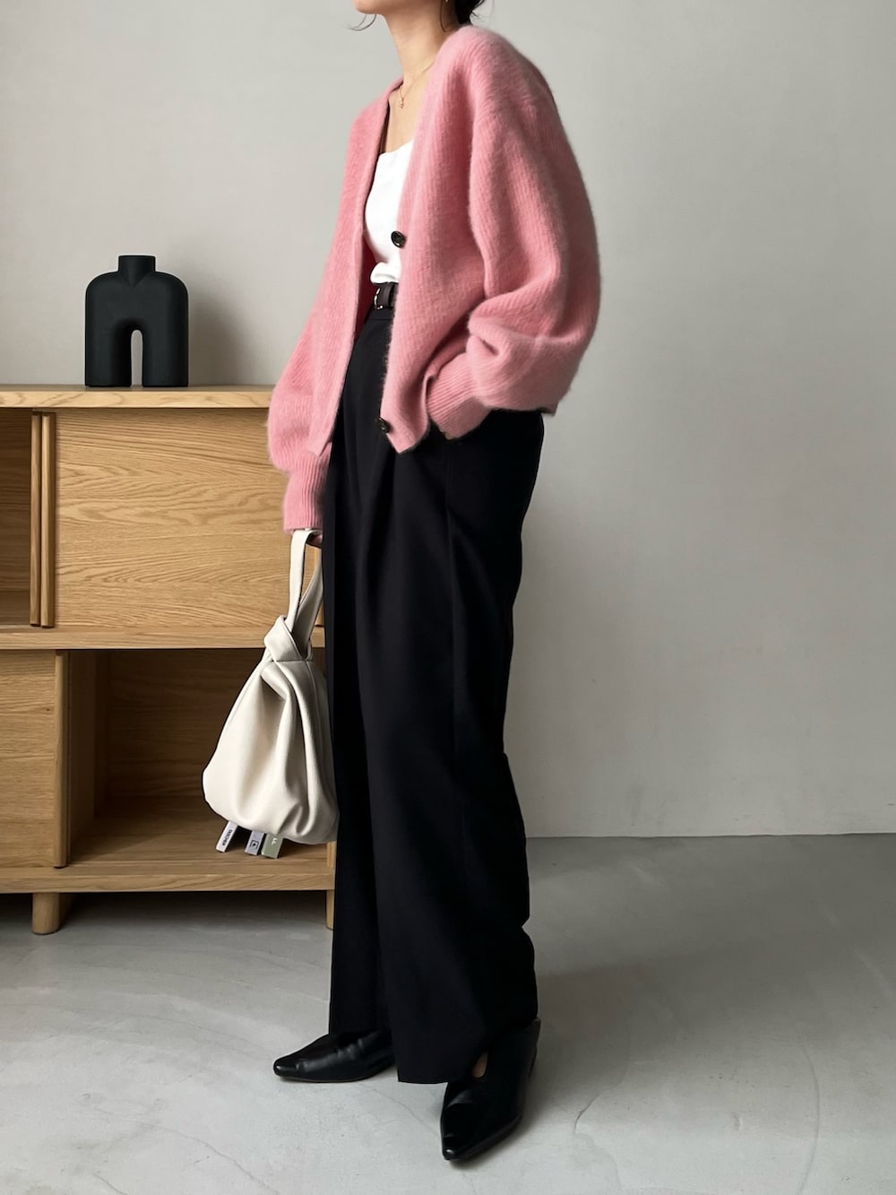 ブラック系のスラックス、ピンク系のカーディガン/ボレロ、ホワイト系のタンクトップを着用したレディースの夏コーディネートの5枚目の写真