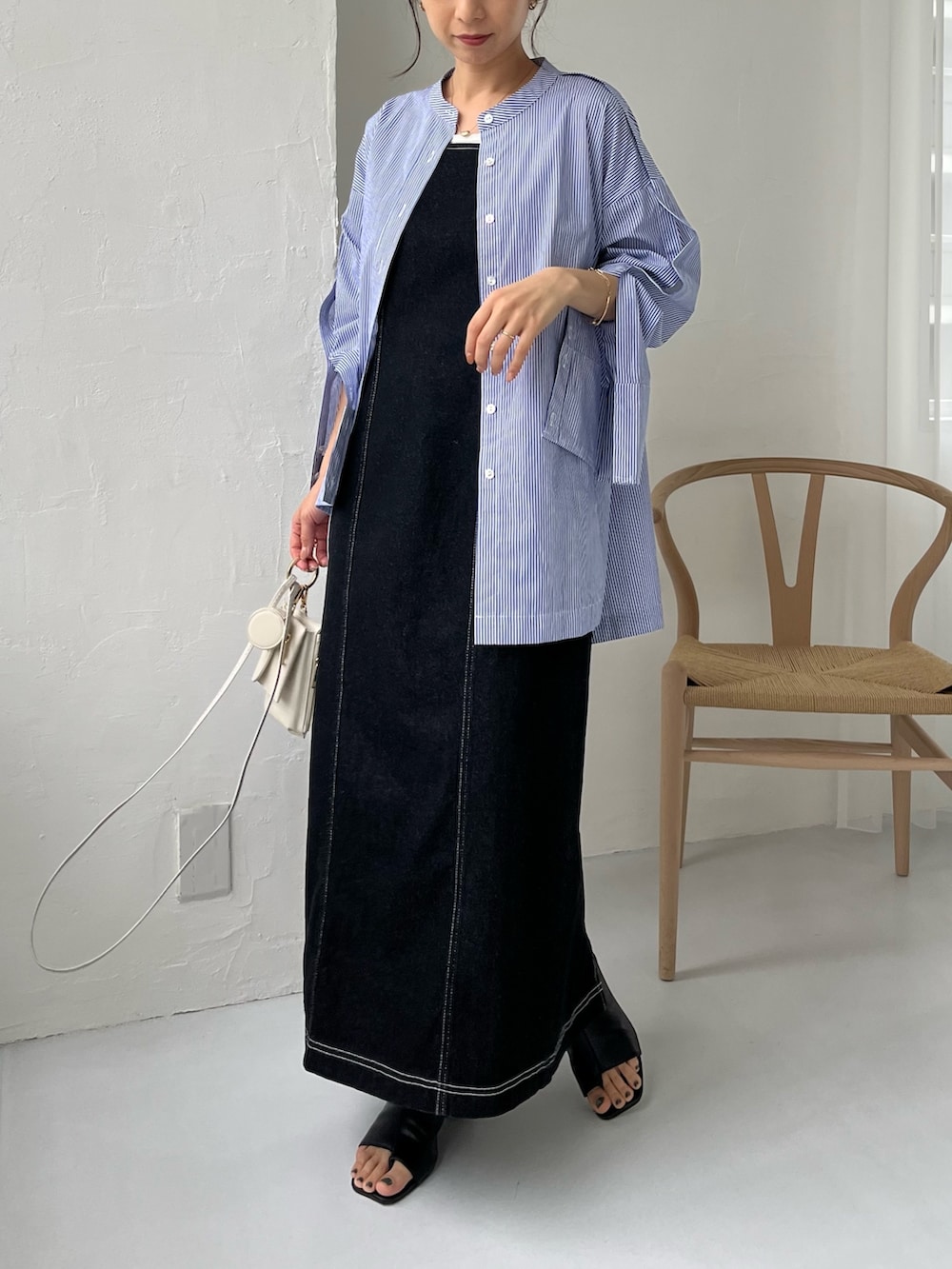 ブルー系のシャツ/ブラウス、ブラック系のワンピース、ブラック系のサンダルを着用したレディースの春コーディネートの2枚目の写真