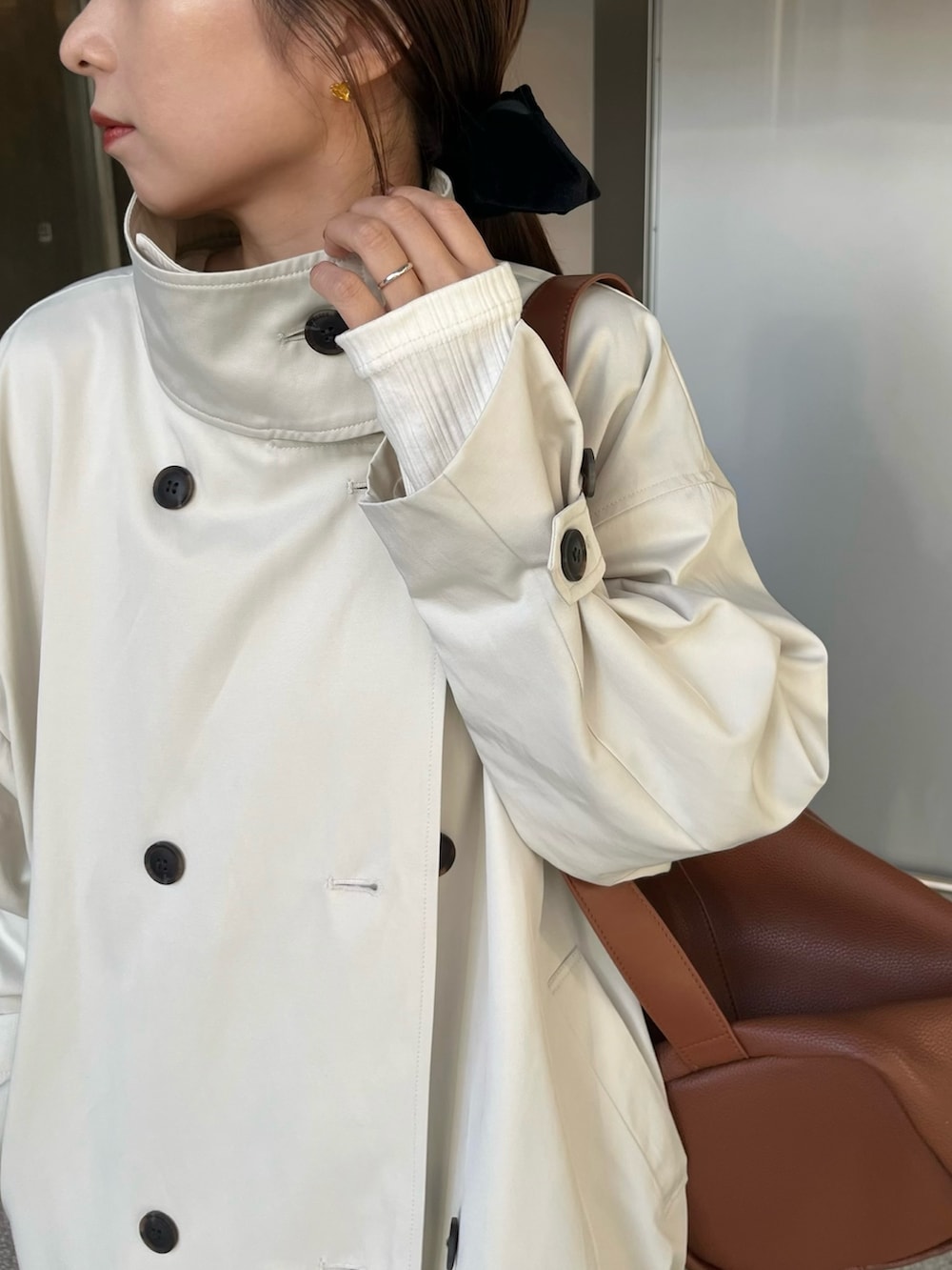 ホワイト系のその他アウター、ブラック系のスカート、イエロー系のショルダーバッグを着用したレディースの冬コーディネートの4枚目の写真