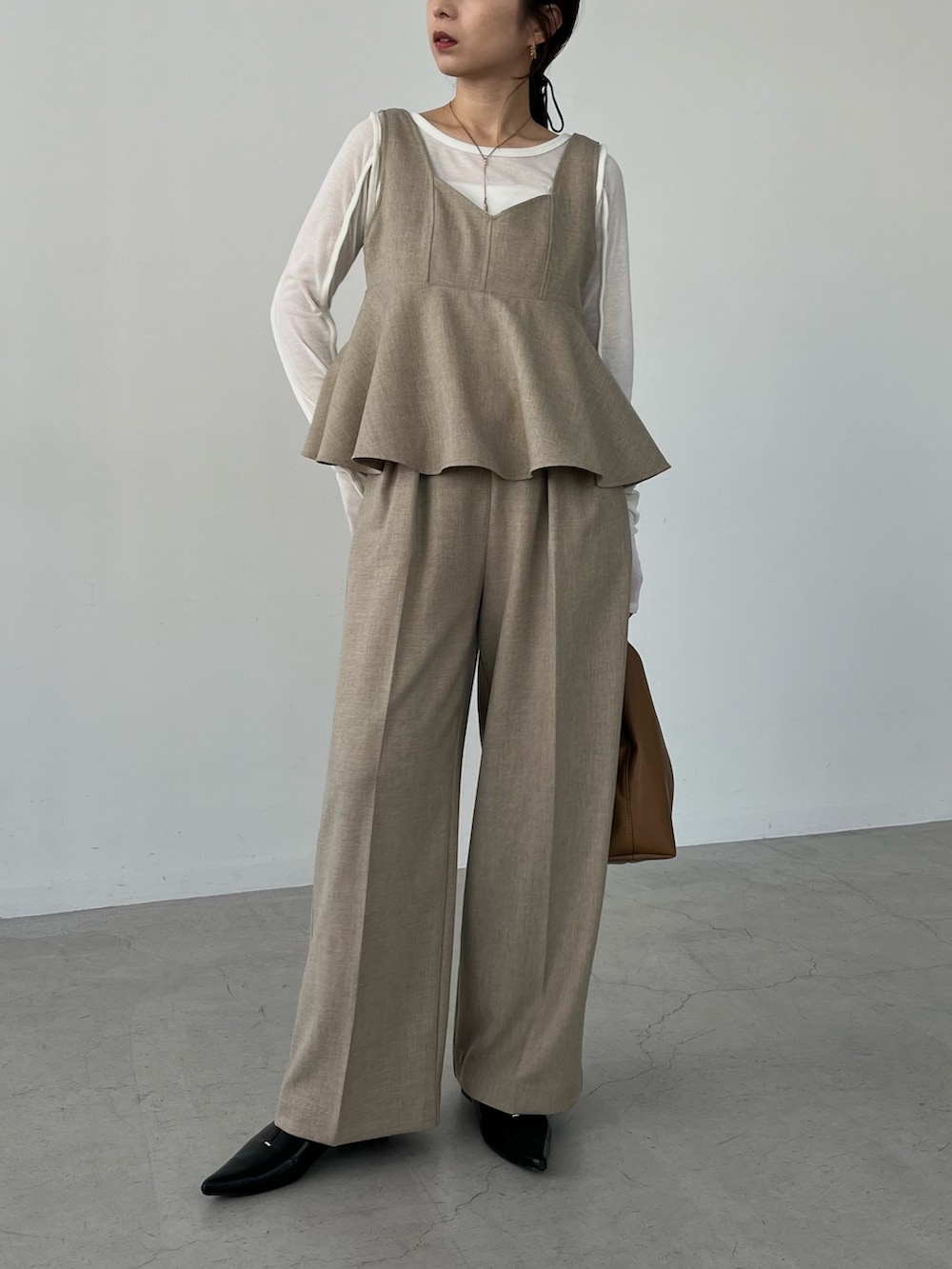 ベージュ系のその他パンツ、イエロー系のショルダーバッグ、ブラック系のパンプスを着用したレディースの冬コーディネートの2枚目の写真