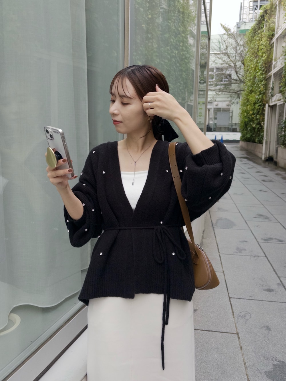 ホワイト系のスカート、ブラック系のカーディガン/ボレロ、イエロー系のショルダーバッグを着用したレディースの秋コーディネートの3枚目の写真