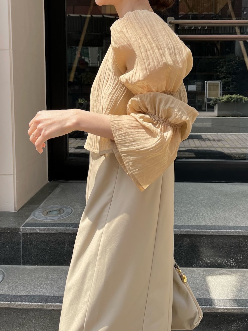 ベージュ系のワンピース、ベージュ系のショルダーバッグ、ホワイト系のその他を着用したレディースの春コーディネートの5枚目の写真