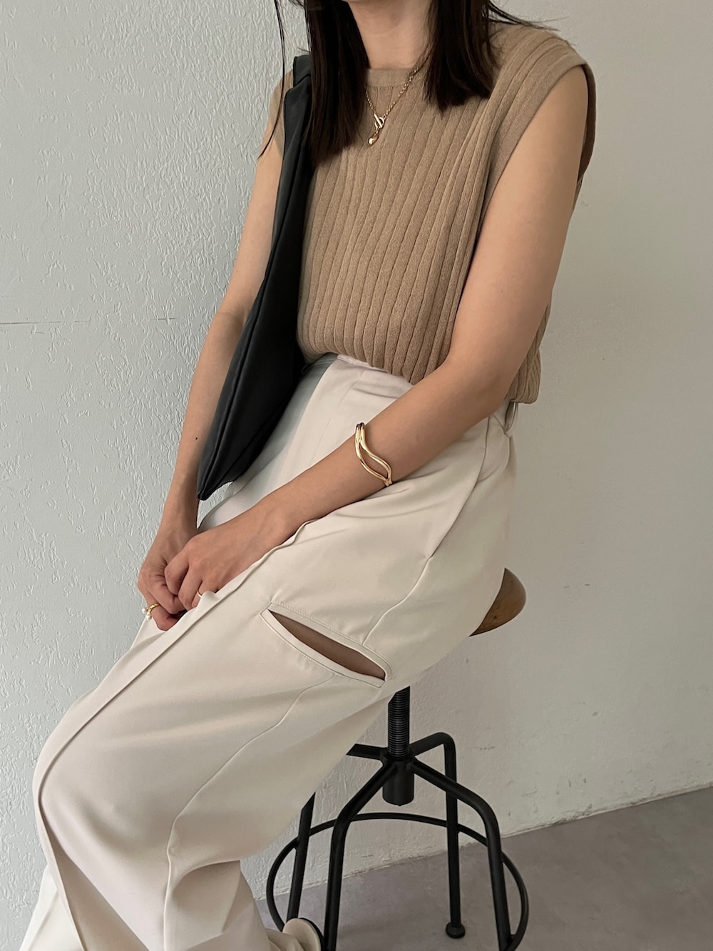 ホワイト系のその他パンツ、ベージュ系のニット/セーター、ブラック系のバッグを着用したレディースの夏コーディネートの4枚目の写真