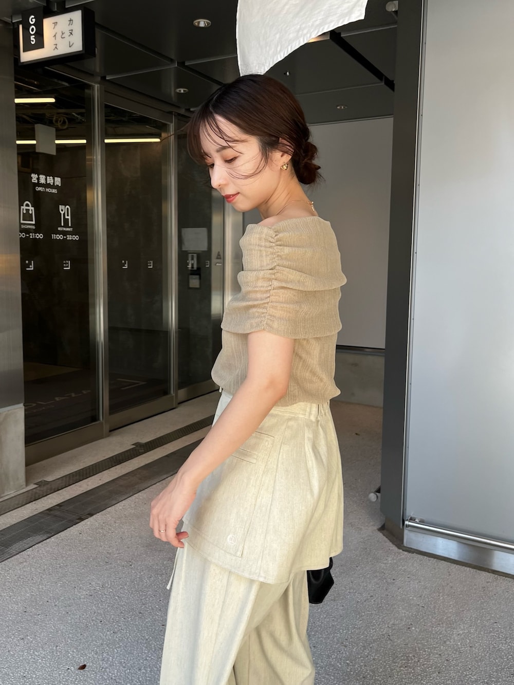 ベージュ系のその他パンツ、ベージュ系のニット/セーター、ブラック系のショルダーバッグを着用したレディースの夏コーディネートの5枚目の写真