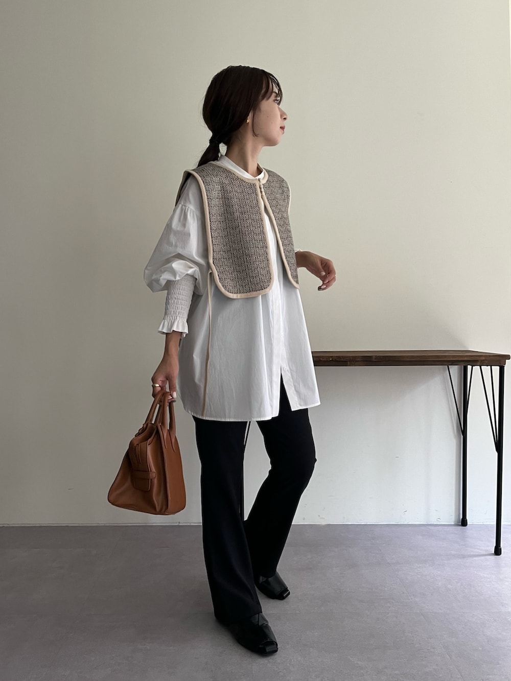 ベージュ系のニット/セーター、ホワイト系のシャツ/ブラウス、ブラウン系のトートバッグを着用したレディースの夏コーディネートの2枚目の写真
