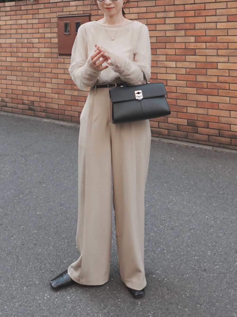 ベージュ系のTシャツ/カットソー、ベージュ系のその他パンツ、ブラック系のハンドバッグを着用したレディースの春コーディネートの3枚目の写真
