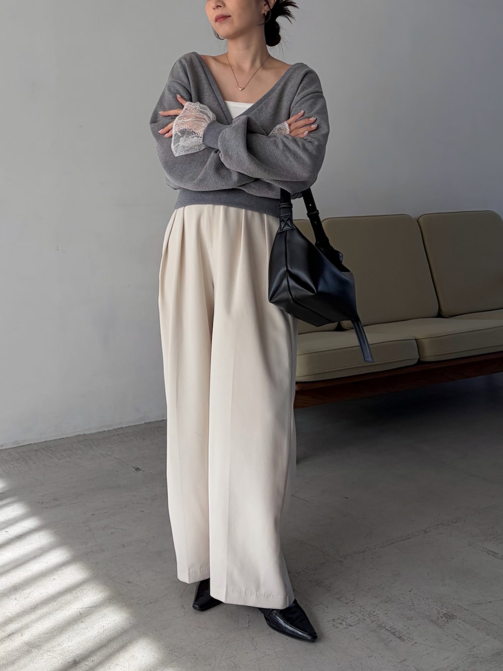 グレー系のTシャツ/カットソー、ホワイト系のその他パンツ、ブラック系のショルダーバッグを着用したレディースの冬コーディネートの3枚目の写真