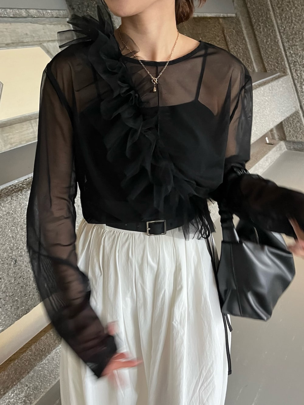 ホワイト系のスカート、ブラック系のTシャツ/カットソー、ブラック系のTシャツ/カットソーを着用したレディースの冬コーディネートの5枚目の写真