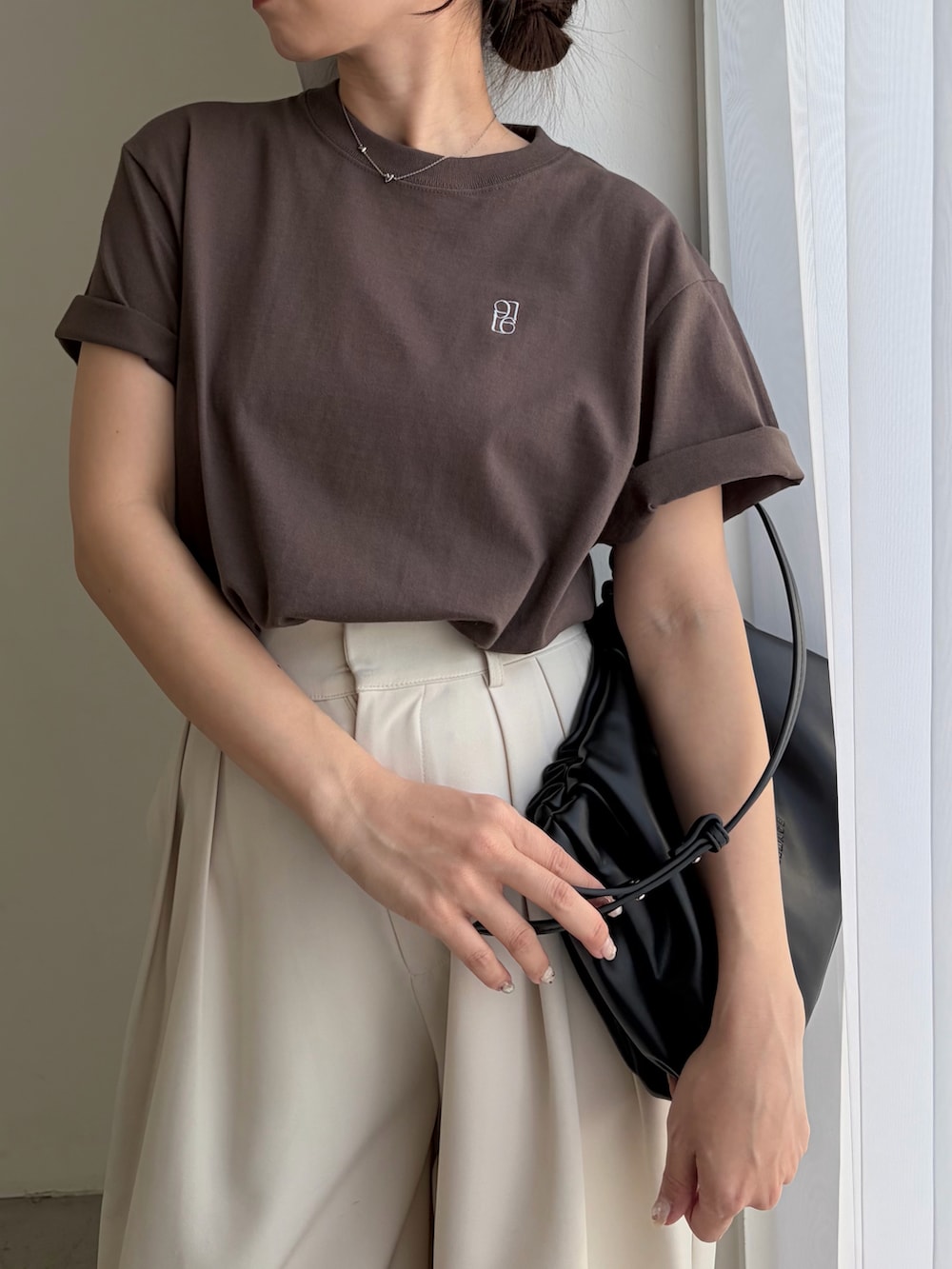 ブラウン系のTシャツ/カットソー、ホワイト系のその他パンツ、ブラック系のショルダーバッグを着用したレディースの春コーディネートの4枚目の写真