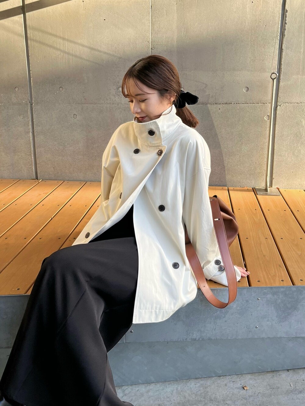 ホワイト系のその他アウター、ブラック系のスカート、イエロー系のショルダーバッグを着用したレディースの冬コーディネートの3枚目の写真