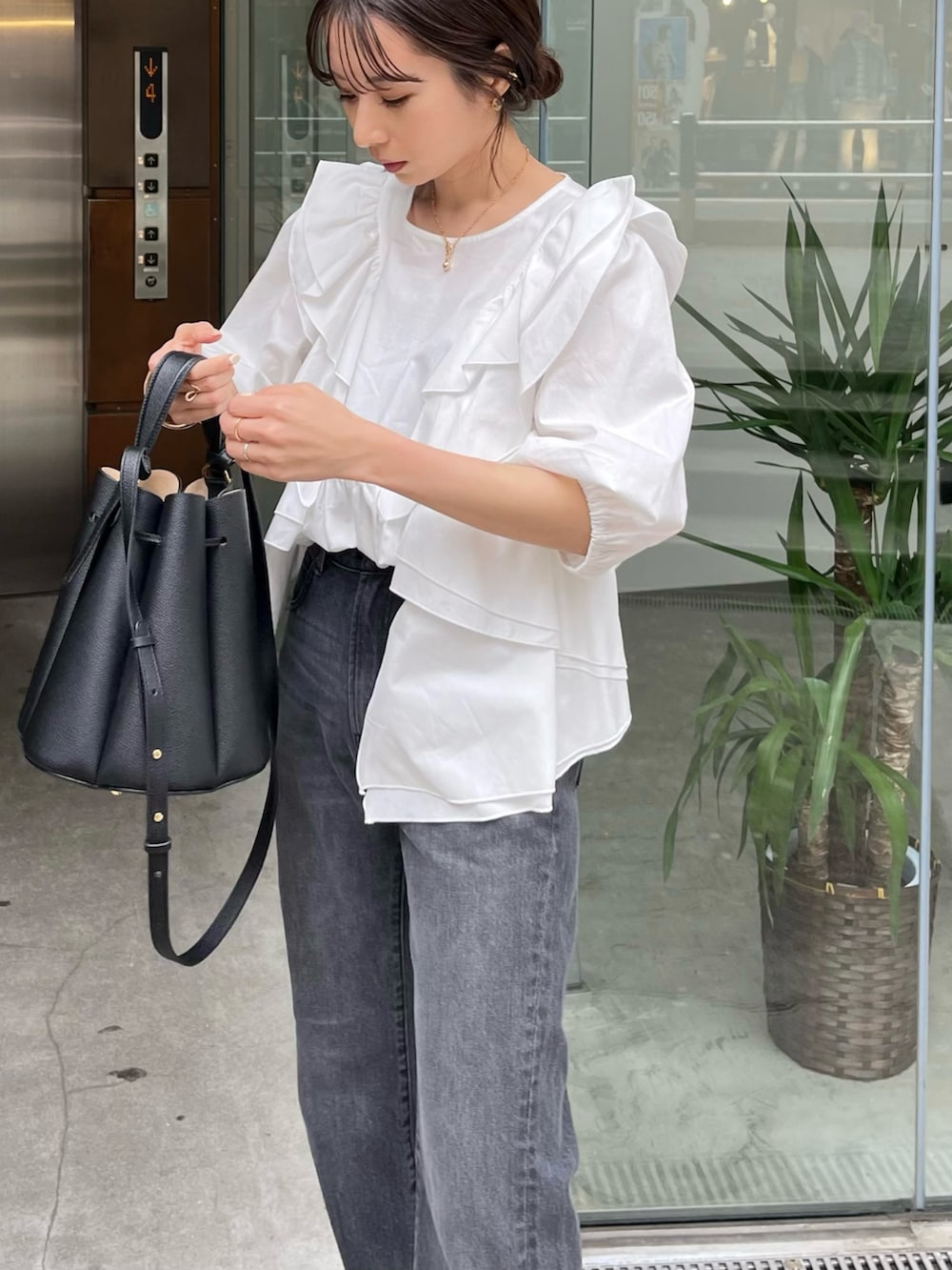 ホワイト系のシャツ/ブラウス、ブラック系のバッグ、ブラック系のサンダルを着用したレディースの春コーディネートの5枚目の写真