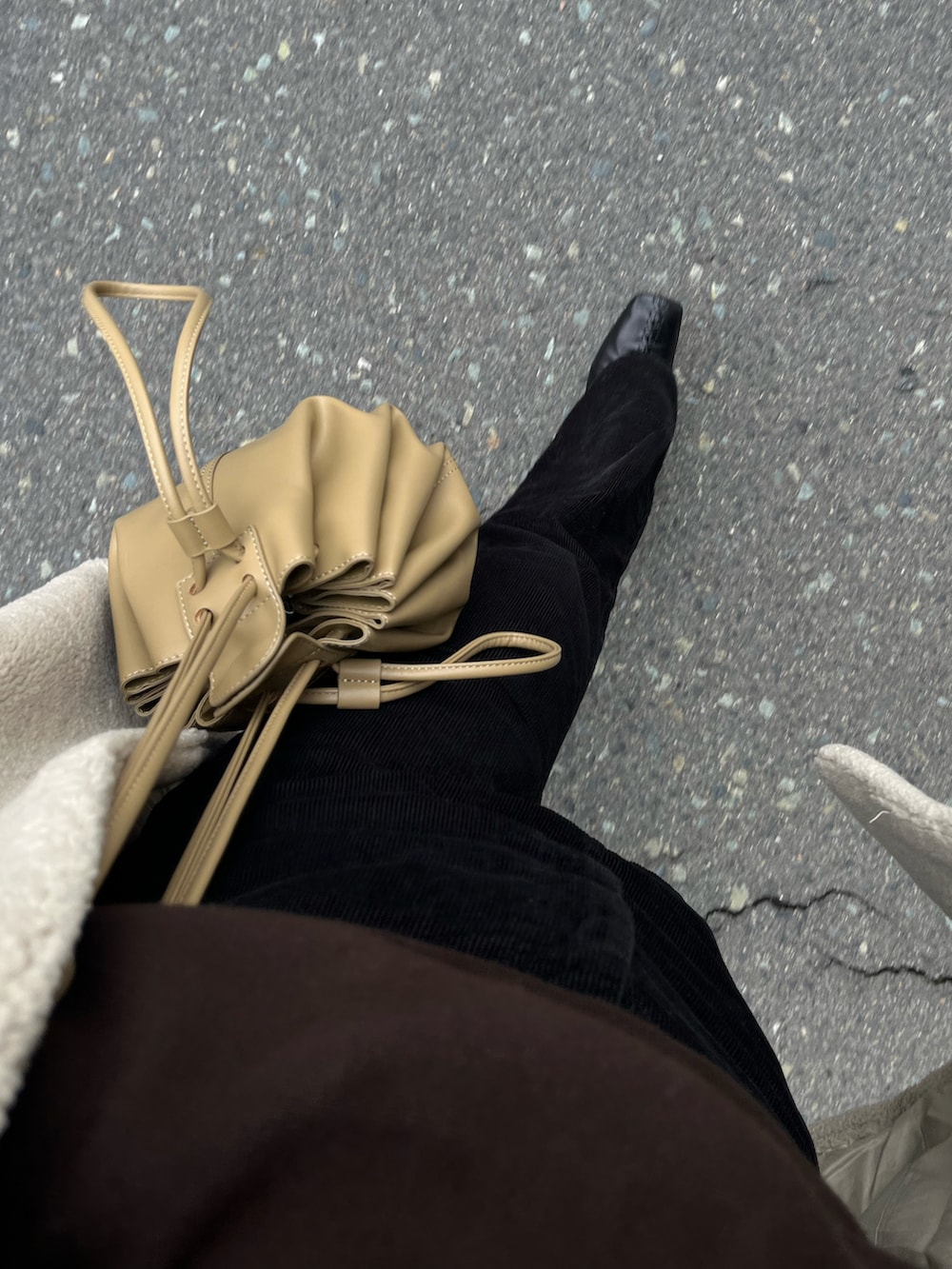 ベージュ系のその他アウター、ベージュ系のショルダーバッグ、ブラック系のその他パンツを着用したレディースの冬コーディネートの5枚目の写真