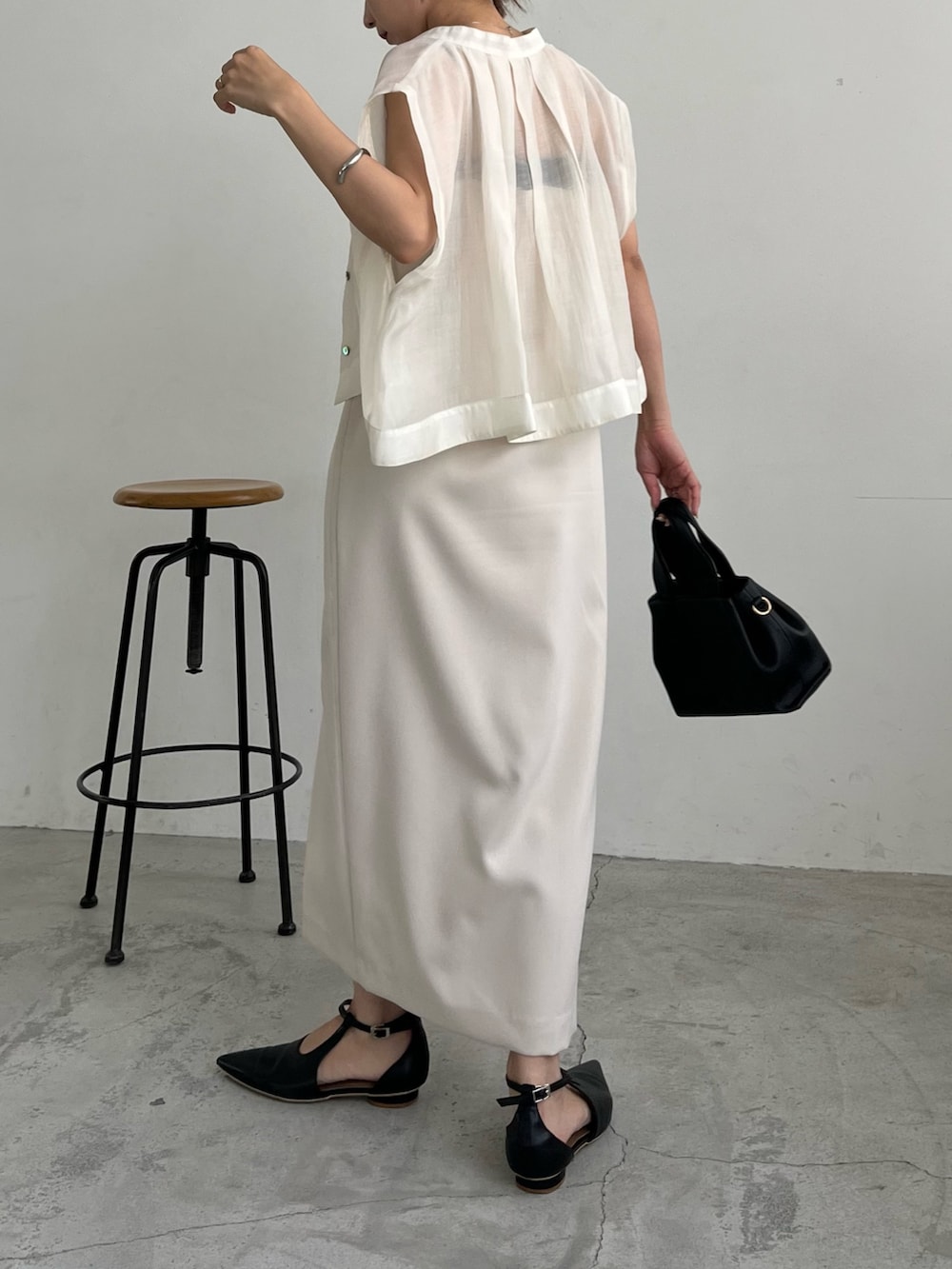 ホワイト系のワンピース、ホワイト系のシャツ/ブラウス、ブラック系のショルダーバッグを着用したレディースの夏コーディネートの3枚目の写真