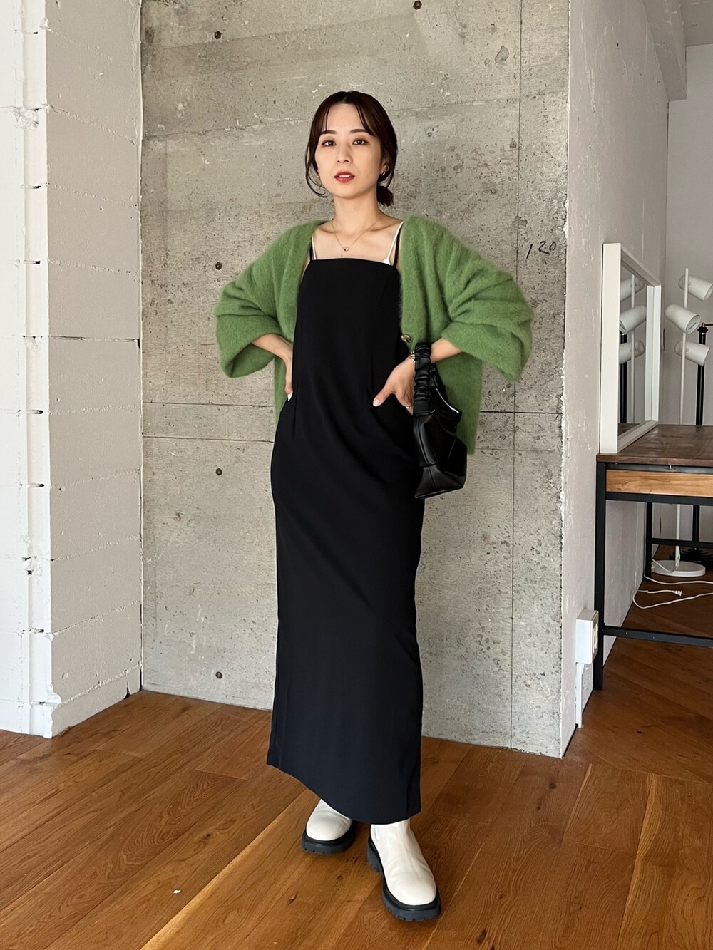 グリーン系のカーディガン/ボレロ、ブラック系のワンピース、ブラック系のハンドバッグを着用したレディースの夏コーディネートの2枚目の写真