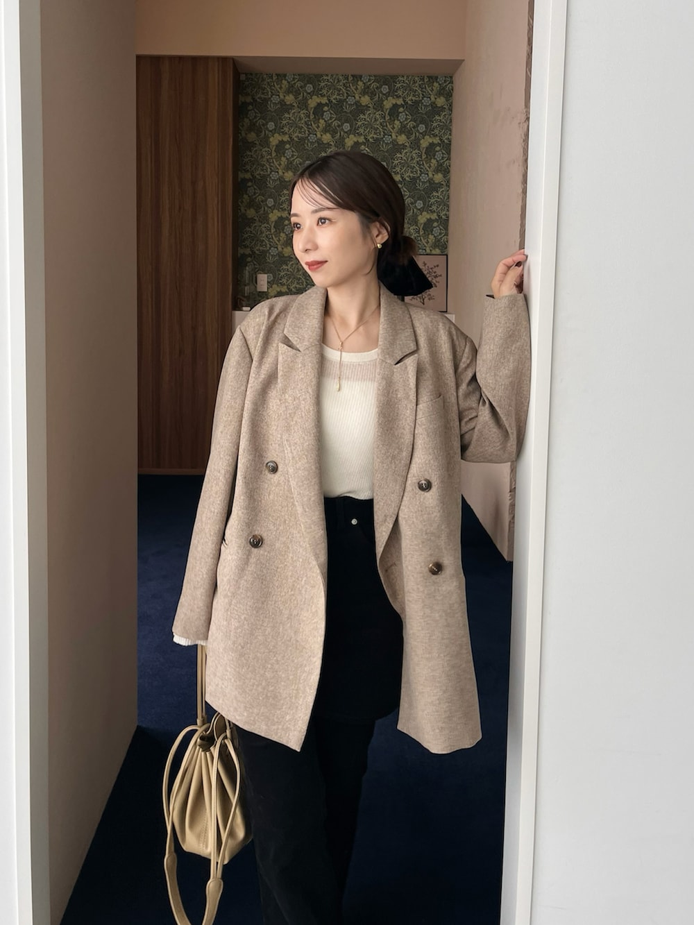 ホワイト系のニット/セーター、ベージュ系のテーラードジャケット、ブラック系のその他パンツを着用したレディースの秋コーディネートの2枚目の写真