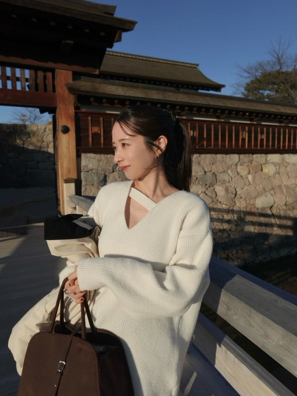 ホワイト系のニット/セーター、ブラック系のブーツ、ブラック系のその他パンツを着用したレディースの冬コーディネートの3枚目の写真