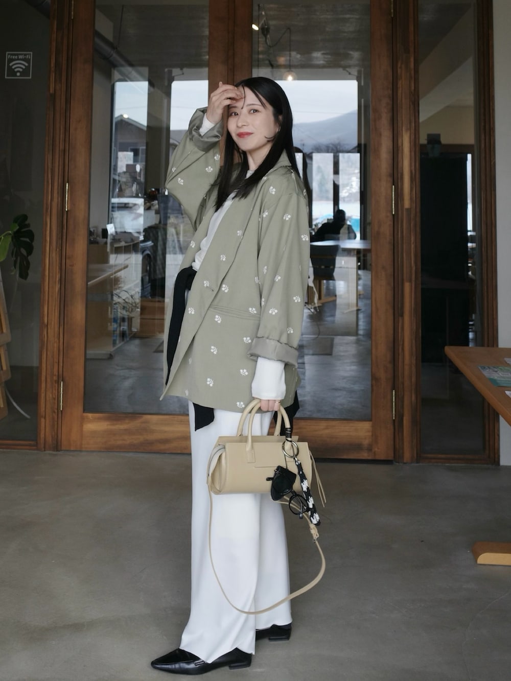 グリーン系のテーラードジャケット、ホワイト系のその他パンツ、ベージュ系のバッグを着用したレディースの春コーディネートの2枚目の写真