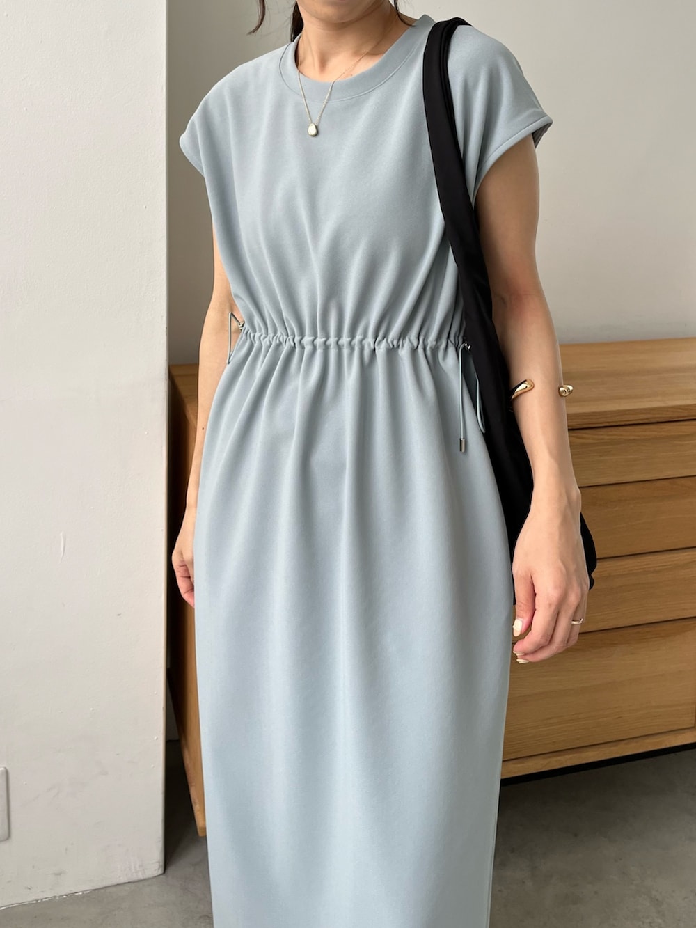 ブルー系のワンピース/ドレス、ブラック系のショルダーバッグ、ホワイト系のサンダルを着用したレディースの春コーディネートの2枚目の写真