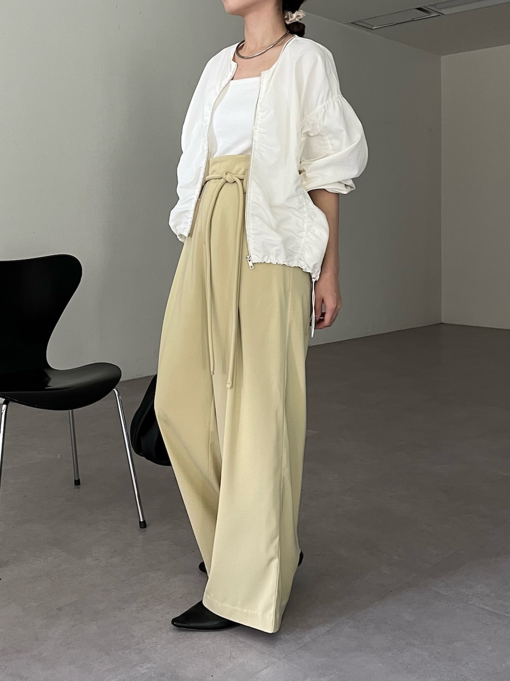 ブラック系のハンドバッグ、グリーン系のその他パンツ、ホワイト系のキャミソールを着用したレディースの春コーディネートの3枚目の写真