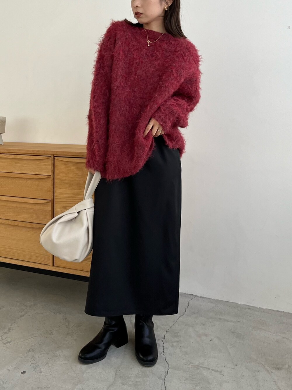 レッド系のカーディガン/ボレロ、ブラック系のワンピース、ホワイト系のハンドバッグを着用したレディースの冬コーディネートの6枚目の写真