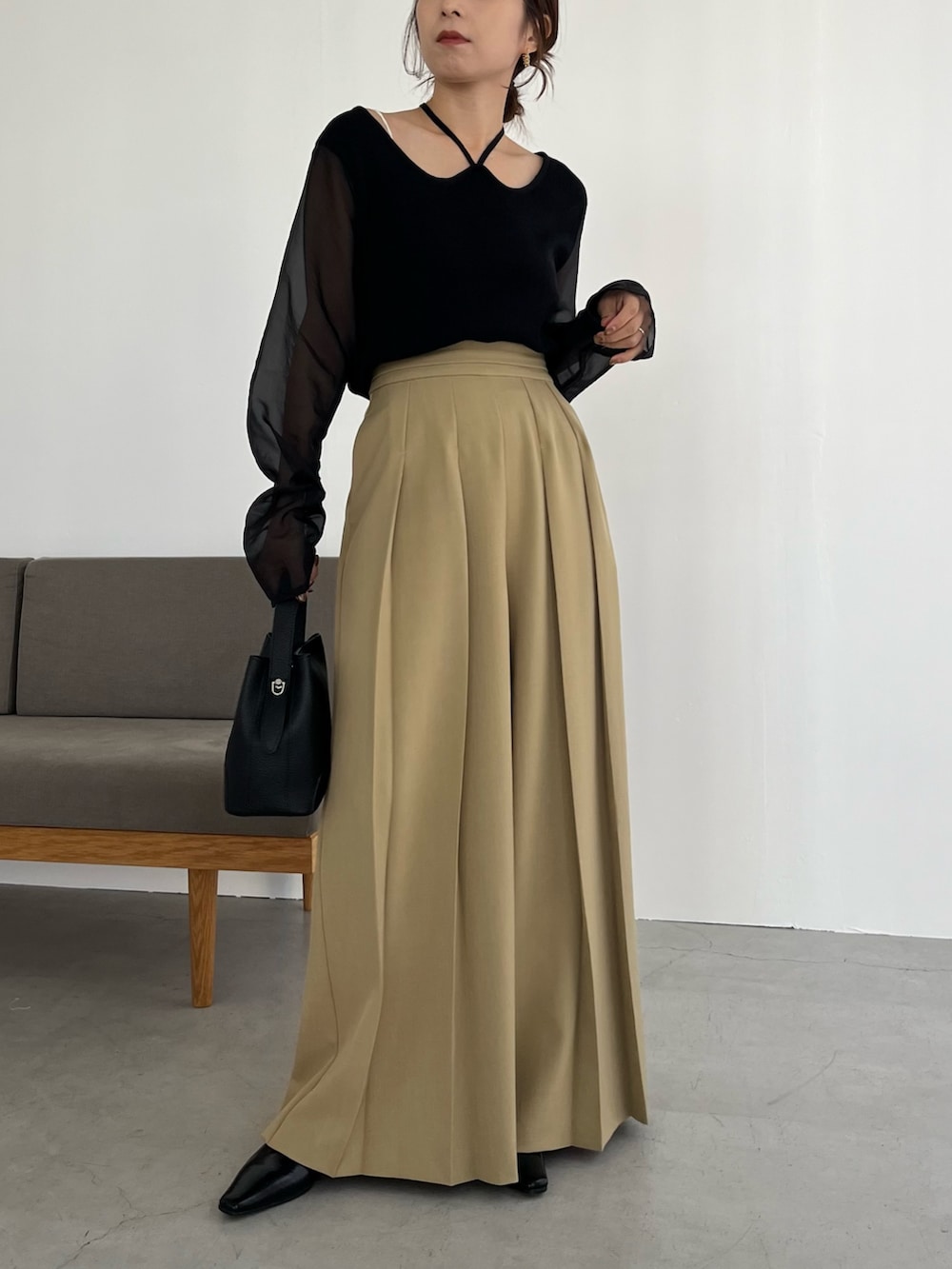 ベージュ系のその他パンツ、ブラック系のニット/セーター、ブラック系のショルダーバッグを着用したレディースの冬コーディネートの4枚目の写真