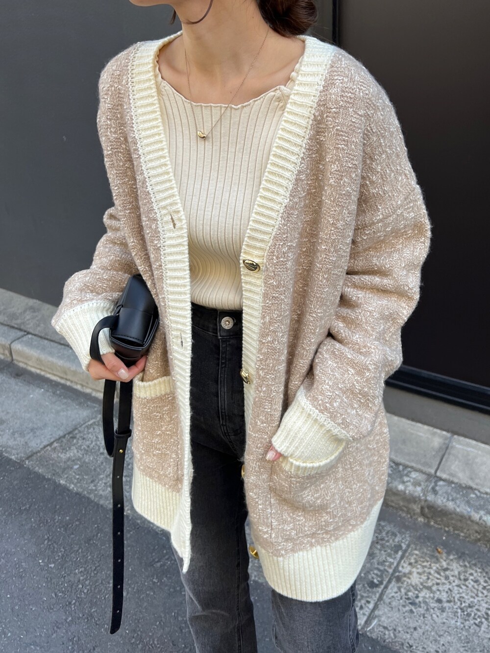 ベージュ系のカーディガン/ボレロ、ホワイト系のニット/セーター、ブラック系のデニムパンツを着用したレディースの秋コーディネートの6枚目の写真