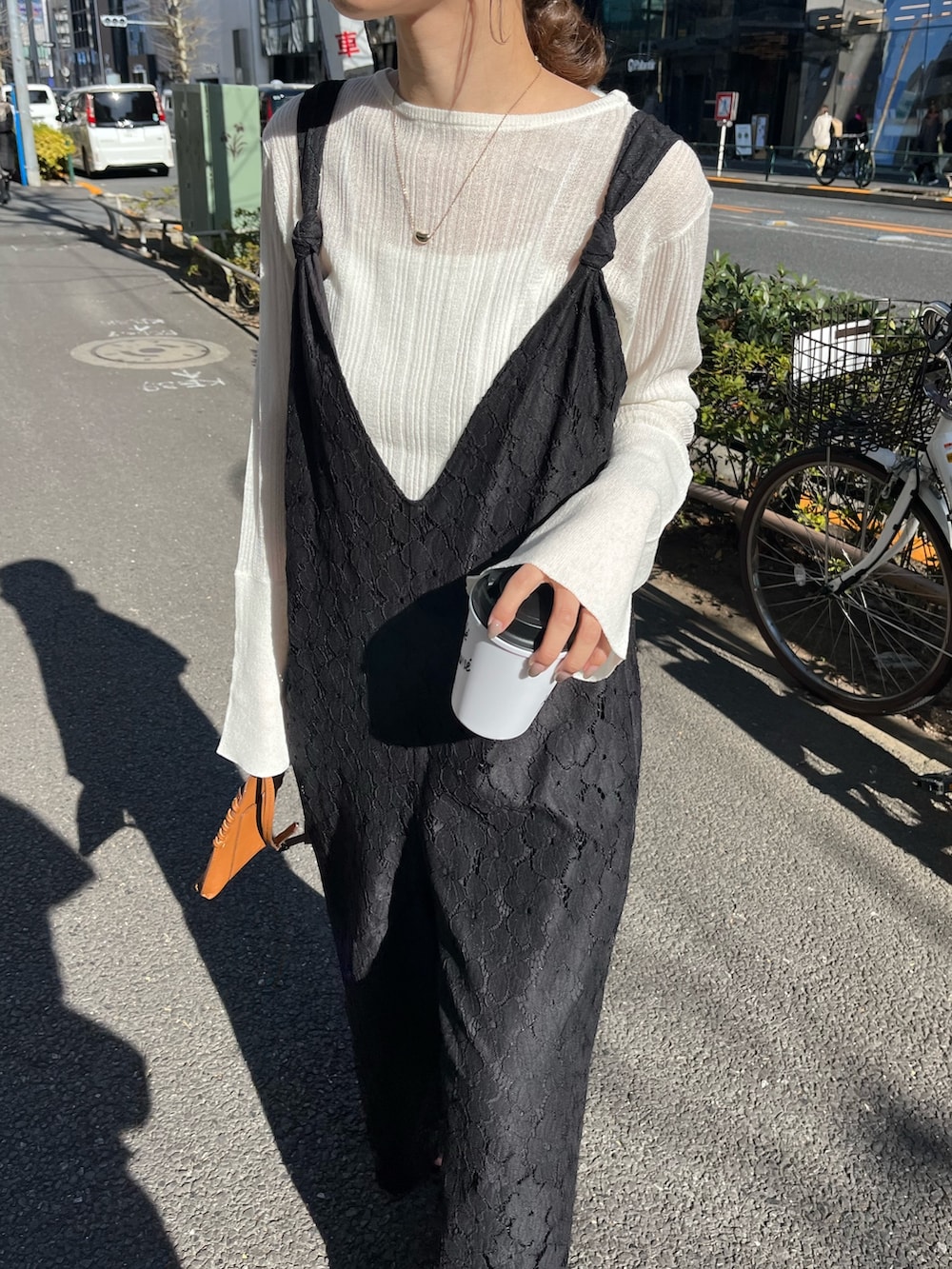 ホワイト系のニット/セーター、ブラック系のサロペット/オーバーオール、ブラウン系のトートバッグを着用したレディースの冬コーディネートの4枚目の写真