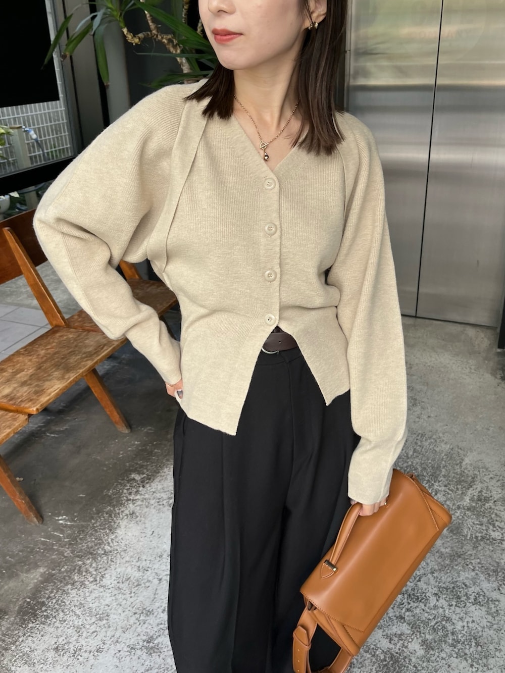 ブラック系のスラックス、ベージュ系のショルダーバッグ、ベージュ系のカーディガン/ボレロを着用したレディースの冬コーディネートの3枚目の写真