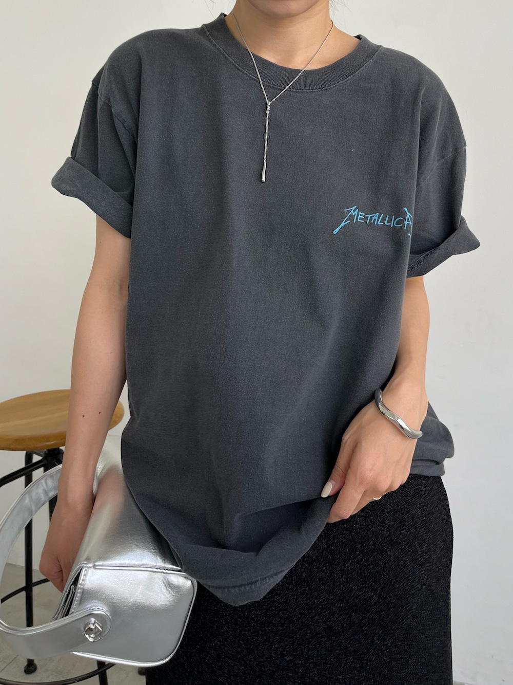 ブラック系のスカート、シルバー系のショルダーバッグ、ブラック系のサンダルを着用したレディースの夏コーディネートの5枚目の写真