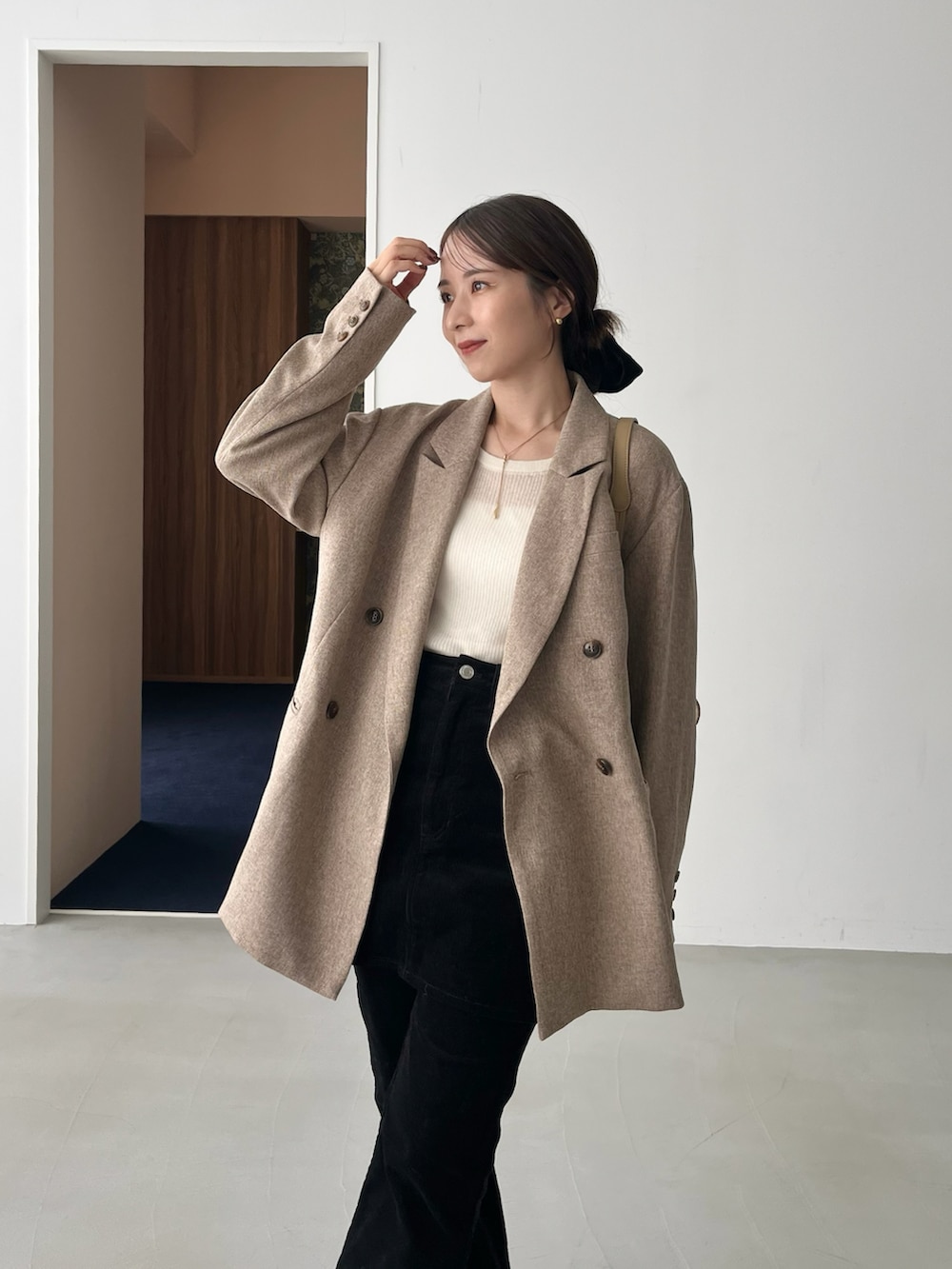 ホワイト系のニット/セーター、ベージュ系のテーラードジャケット、ブラック系のその他パンツを着用したレディースの秋コーディネートの3枚目の写真