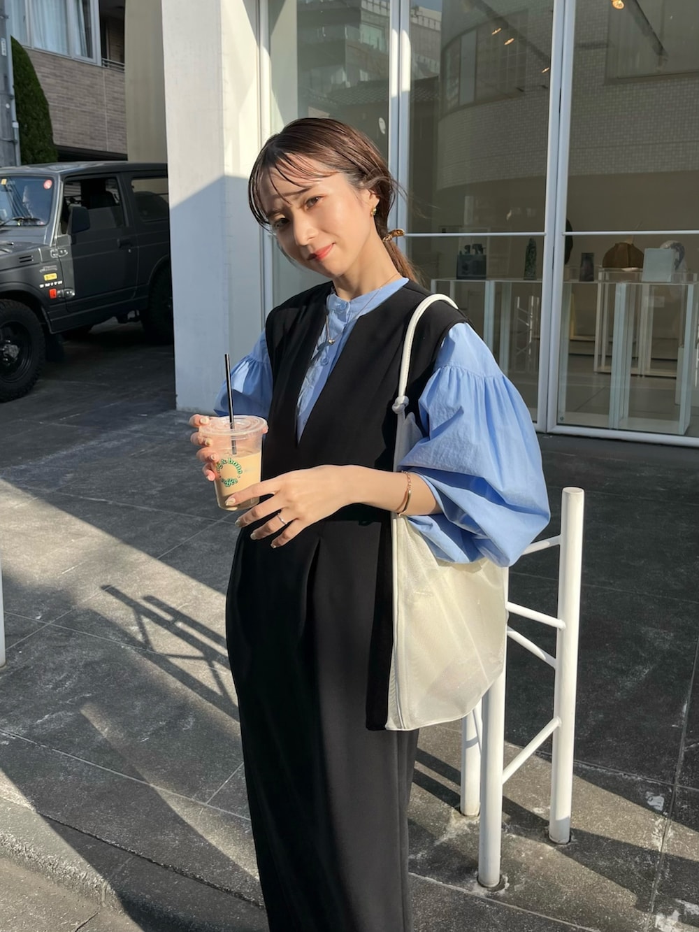 ブラック系のワンピース/ドレス、ブルー系のシャツ/ブラウス、ホワイト系のサンダルを着用したレディースの春コーディネートの3枚目の写真