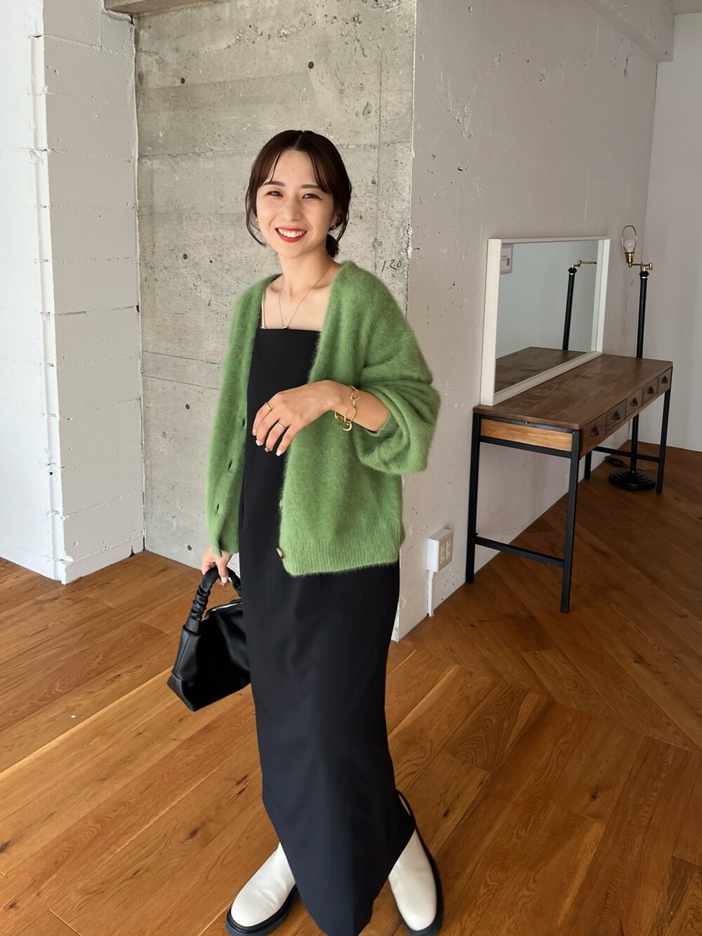 グリーン系のカーディガン/ボレロ、ブラック系のワンピース、ブラック系のハンドバッグを着用したレディースの夏コーディネートの4枚目の写真