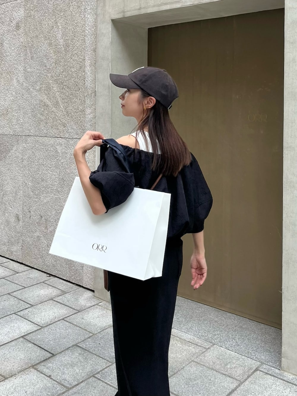 ブラック系のスカート、ブラック系のシャツ/ブラウス、ブラウン系のショルダーバッグを着用したレディースの秋コーディネートの4枚目の写真