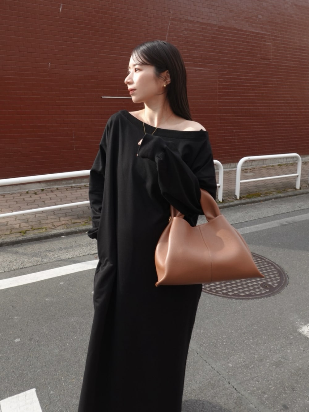 ブラック系のワンピース、ホワイト系のスニーカー、ブラウン系のバッグを着用したレディースの冬コーディネートの4枚目の写真