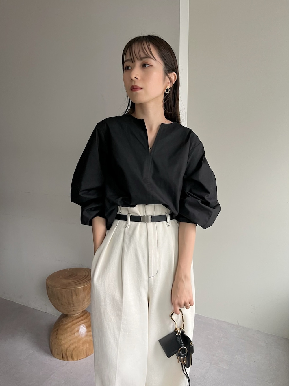 ホワイト系のデニムパンツ、ブラック系のシャツ/ブラウス、ホワイト系のシューズを着用したレディースの春コーディネートの3枚目の写真
