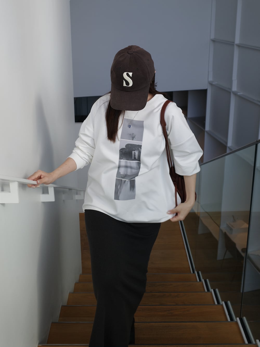 ホワイト系のTシャツ/カットソー、ブラウン系のショルダーバッグ、グレー系のスカートを着用したレディースの冬コーディネートの2枚目の写真