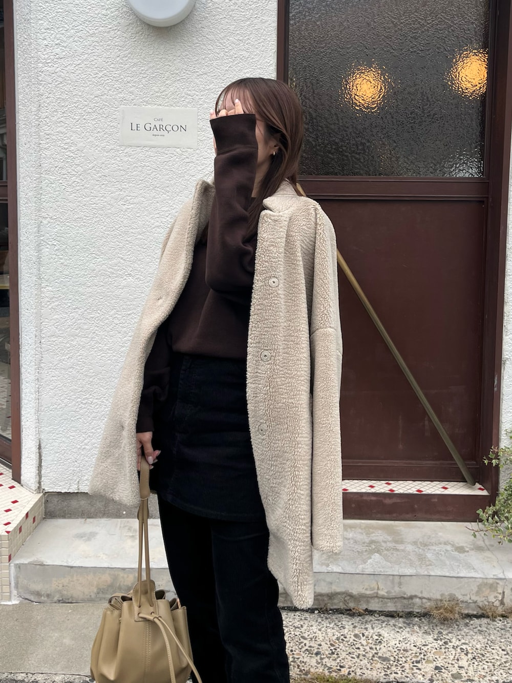 ベージュ系のその他アウター、ベージュ系のショルダーバッグ、ブラック系のその他パンツを着用したレディースの冬コーディネートの3枚目の写真