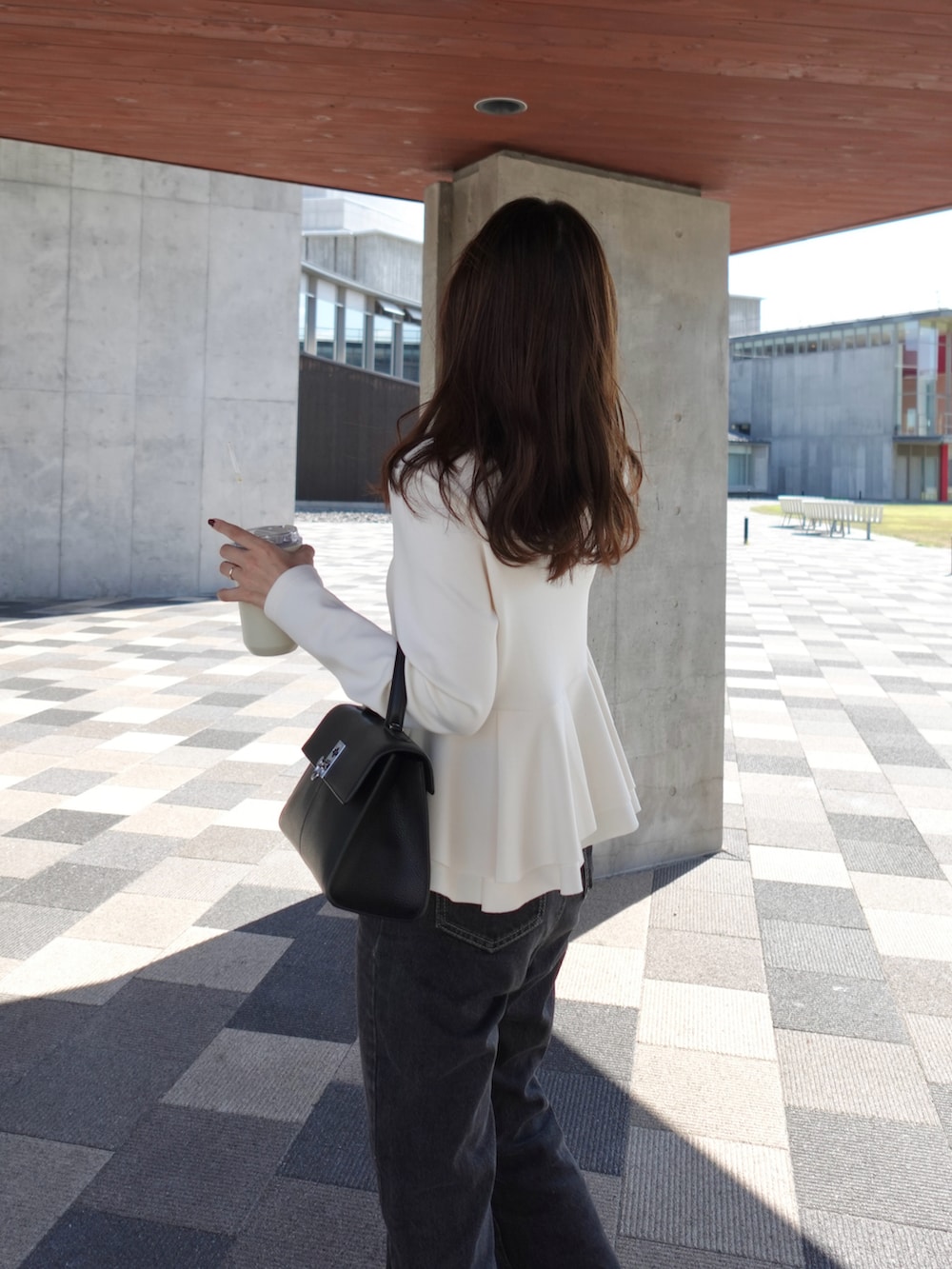 ホワイト系のTシャツ/カットソー、ブラック系のデニムパンツ、ブラック系のバレエシューズを着用したレディースの秋コーディネートの4枚目の写真