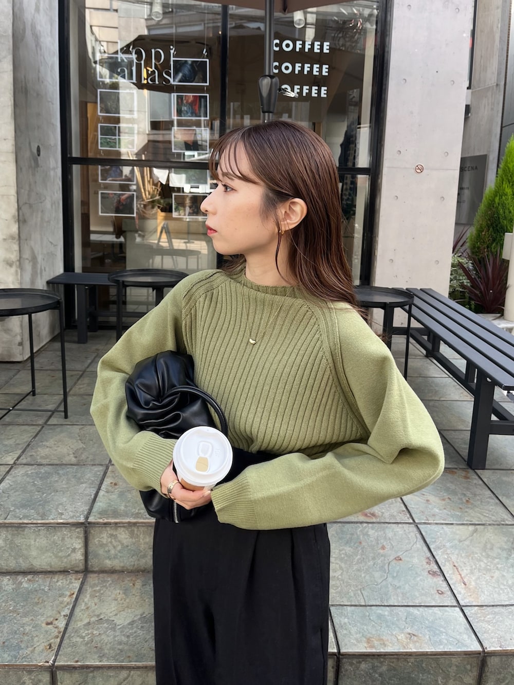 ブラック系のその他パンツ、グリーン系のニット/セーター、ブラック系のトートバッグを着用したレディースの冬コーディネートの2枚目の写真