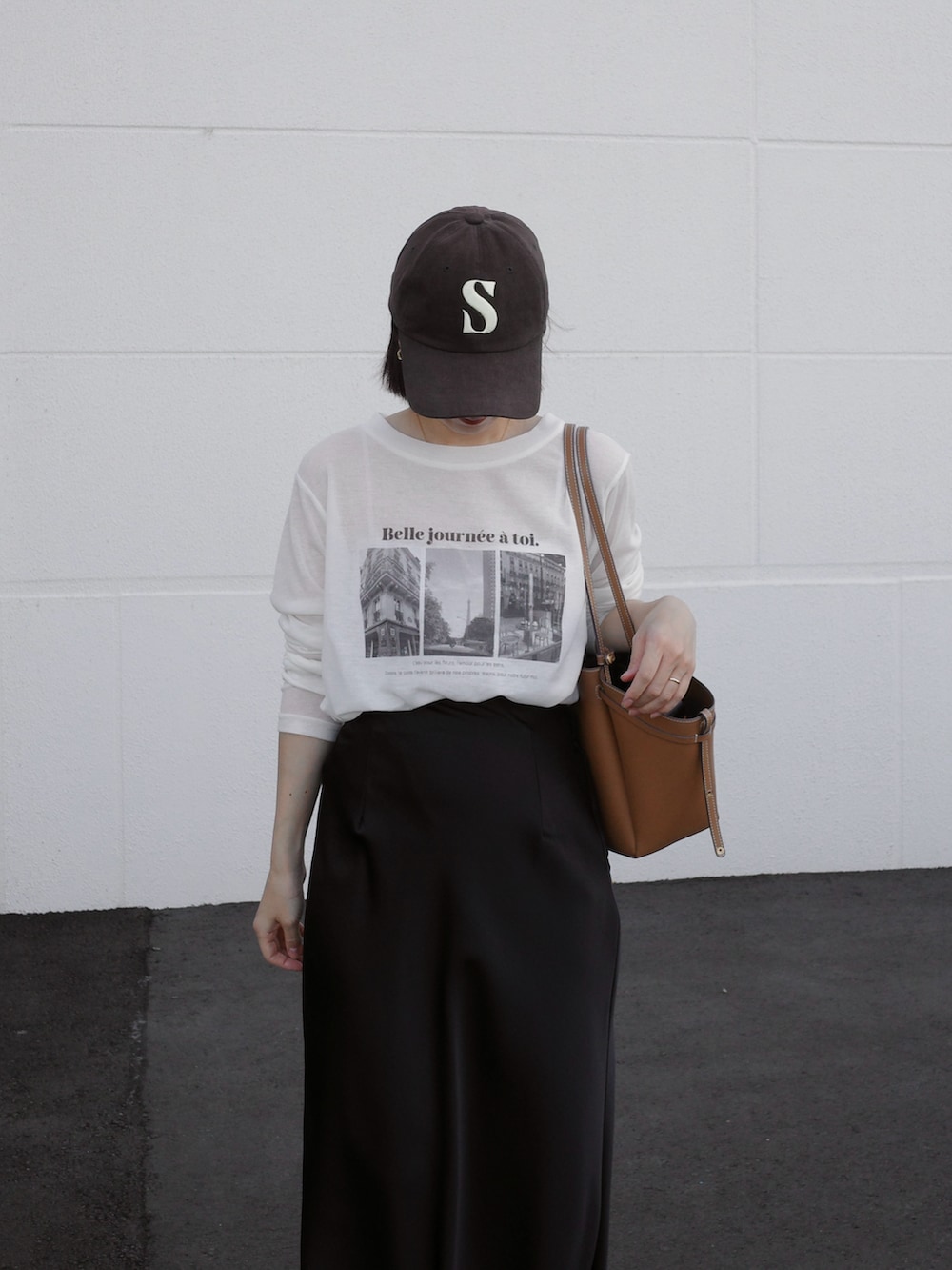 ブラック系のスカート、ホワイト系のTシャツ/カットソー、イエロー系のショルダーバッグを着用したレディースの秋コーディネートの3枚目の写真