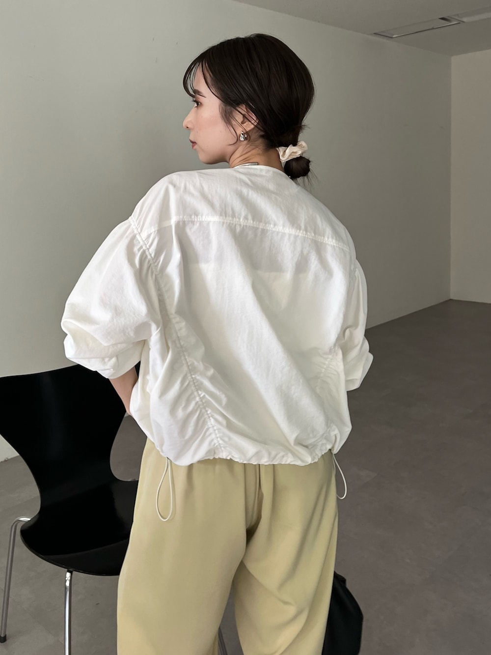 ブラック系のハンドバッグ、グリーン系のその他パンツ、ホワイト系のキャミソールを着用したレディースの春コーディネートの6枚目の写真