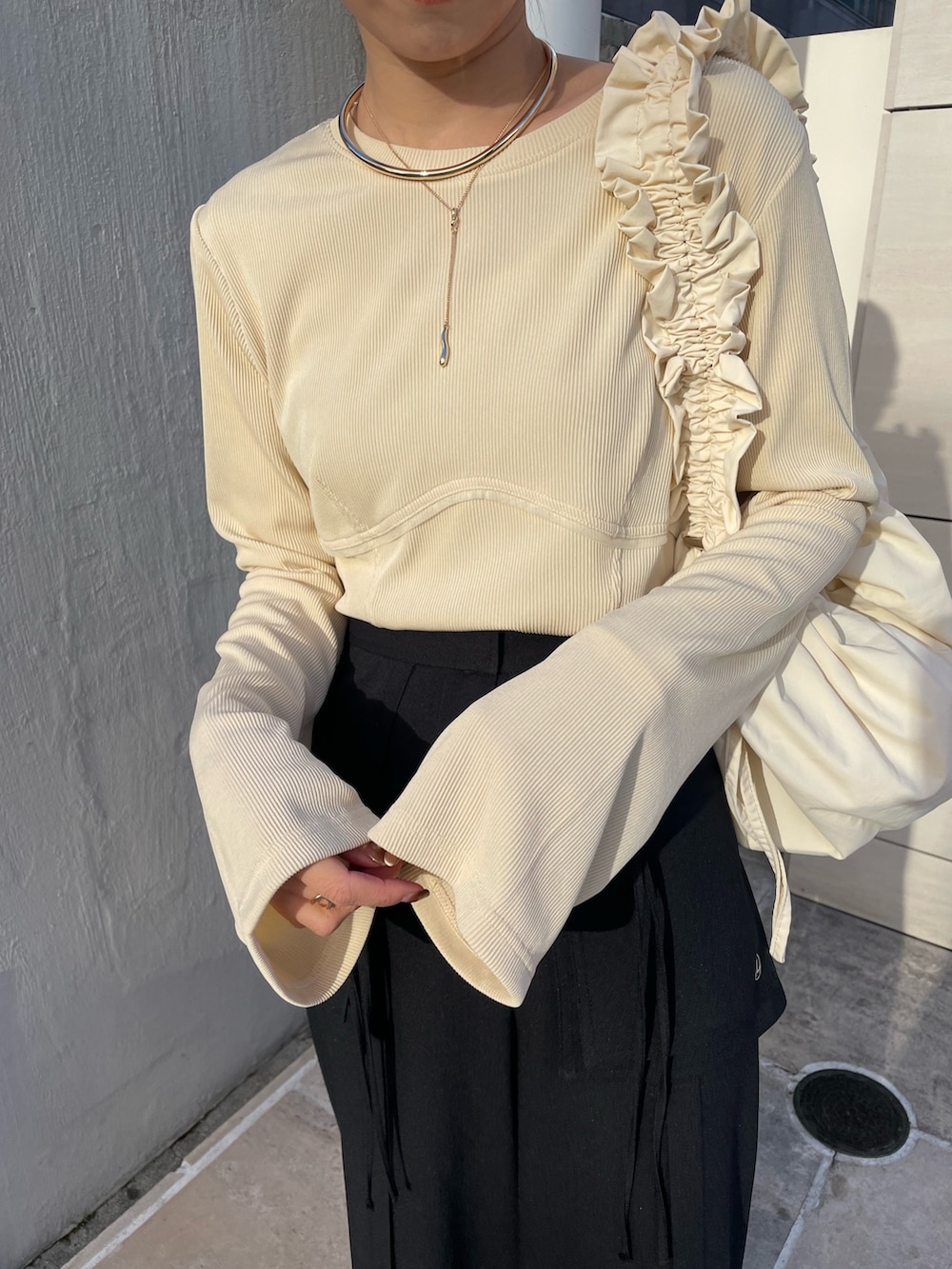 ブラック系のその他パンツ、ブラック系のパンプス、ベージュ系のTシャツ/カットソーを着用したレディースの冬コーディネートの6枚目の写真