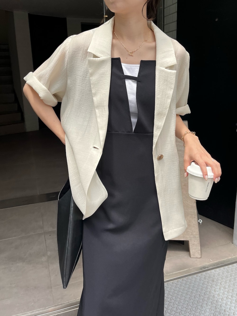 ブラック系のワンピース、ブラック系のその他シューズ、ホワイト系のテーラードジャケットを着用したレディースの春コーディネートの6枚目の写真