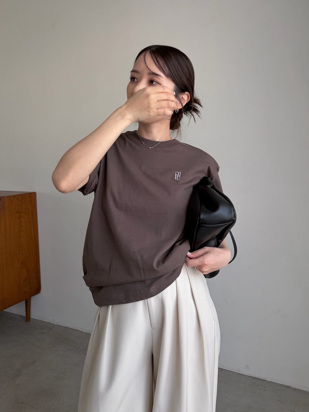 ブラウン系のTシャツ/カットソー、ホワイト系のその他パンツ、ブラック系のショルダーバッグを着用したレディースの春コーディネートの3枚目の写真